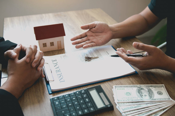 Les clients qui achètent des maisons négocient le coût de l'assurance habitation avec les agents
. - Photo, image