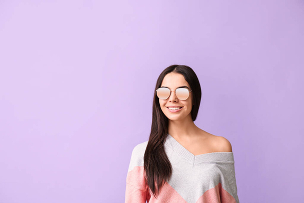Young woman with stylish sunglasses on color background - Foto, Bild