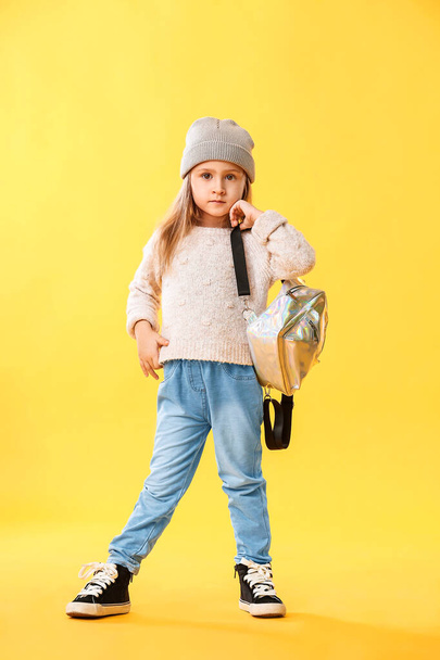 Cute little girl with backpack on color background - Photo, Image