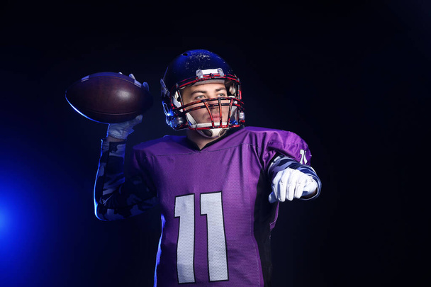 American Football speler op donkere achtergrond - Foto, afbeelding