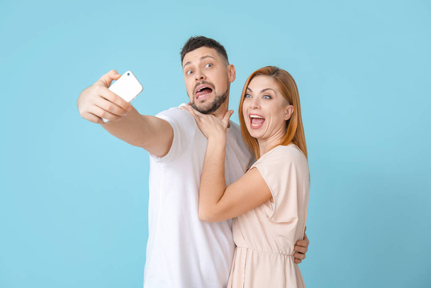 Couple taking selfie on color background - Foto, afbeelding