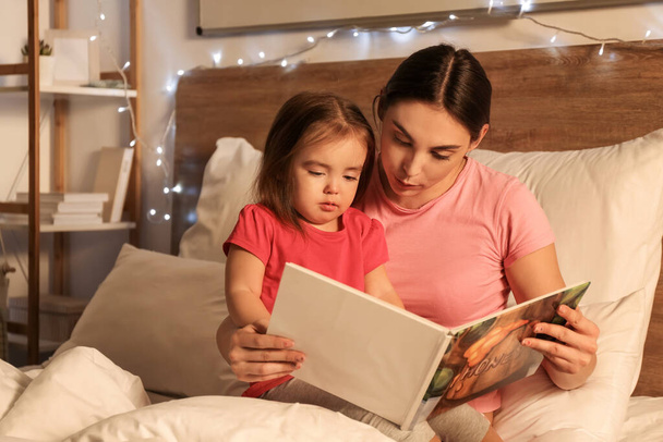 Mutter und ihre kleine Tochter lesen Gute-Nacht-Geschichte zu Hause - Foto, Bild