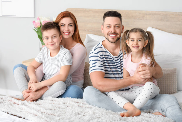 Familia feliz en el dormitorio en casa
 - Foto, imagen