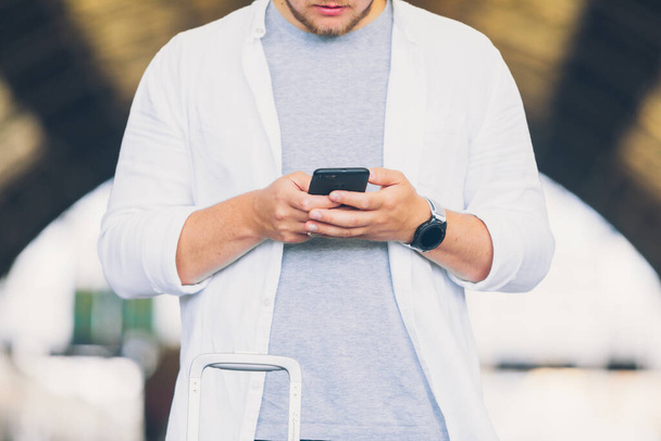 man outdoors holding phone in his hand crop image - Фото, зображення