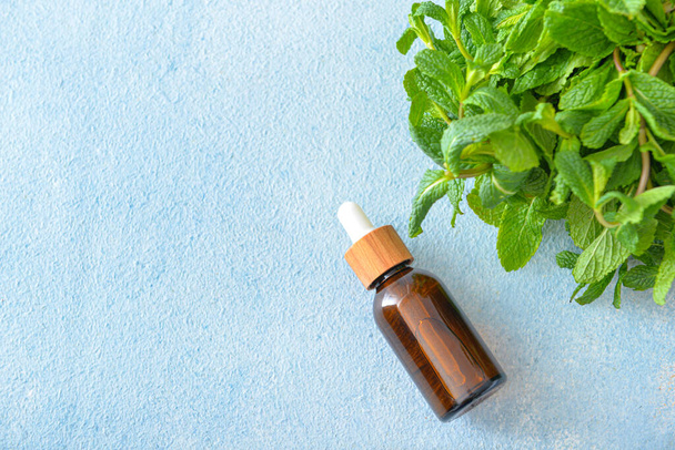 Bottle of mint essential oil on table - Photo, Image