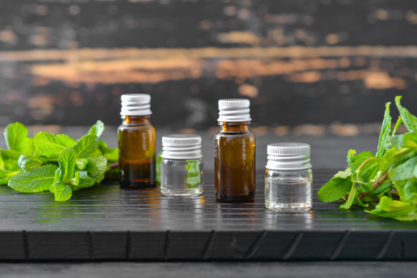 Пляшки ефірної олії м'яти на столі
 - Фото, зображення