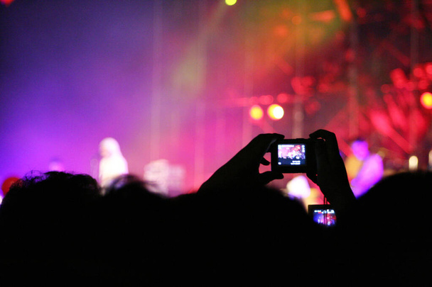 Σιλουέτες των ανθρώπων στη μουσική συναυλία λήψη φωτογραφιών με την κάμερα - Φωτογραφία, εικόνα