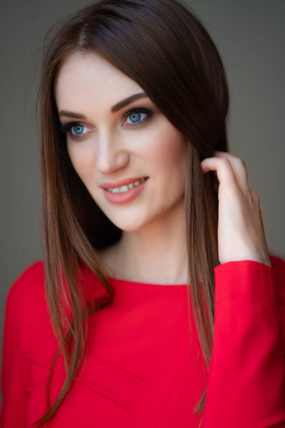 portrait beautiful girl in red corrects hair - Foto, Bild