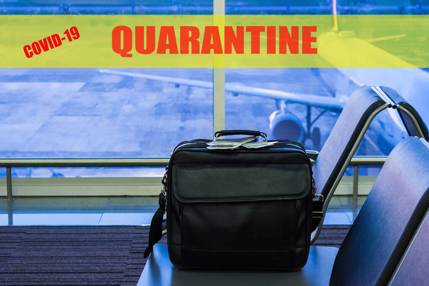 Suitcase in airport departure lounge, airplane in background, Quarantine sign. Covid-19 concept - Foto, afbeelding