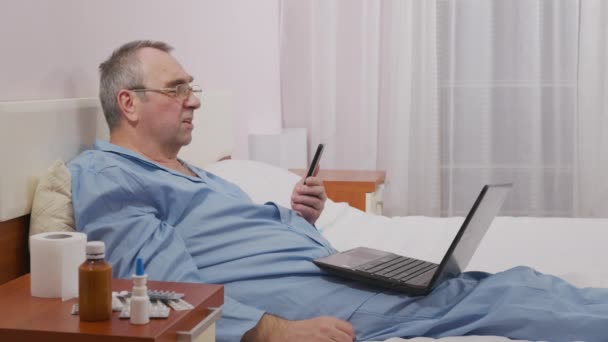Een man communiceert met familieleden tijdens ziekte, isolatie tijdens ziekte. - Video