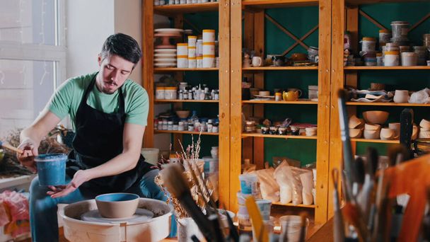 Cerâmica - o mestre oleiros está sentado em sua oficina entre suas ferramentas
 - Foto, Imagem