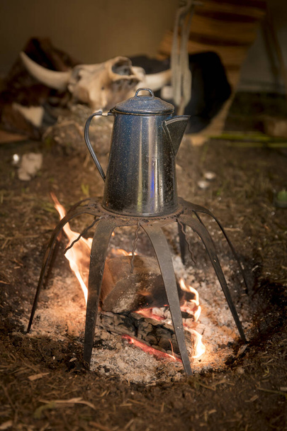 Starý kovový hrnec na kávu stojí nad ohněm na polici - Fotografie, Obrázek