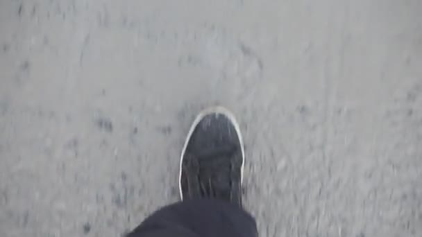 man in black sneakers is walking on a dirt road. bad weather, snow melts, spring - Felvétel, videó