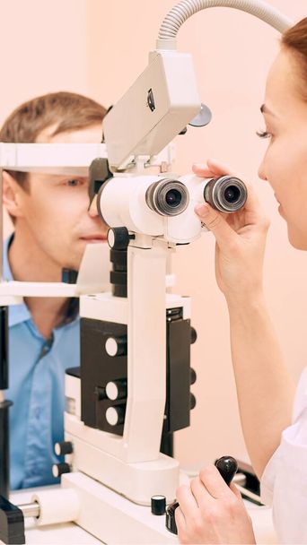ophthalmologist doctor exam optician laboratory with male patient. Men eye care - Valokuva, kuva