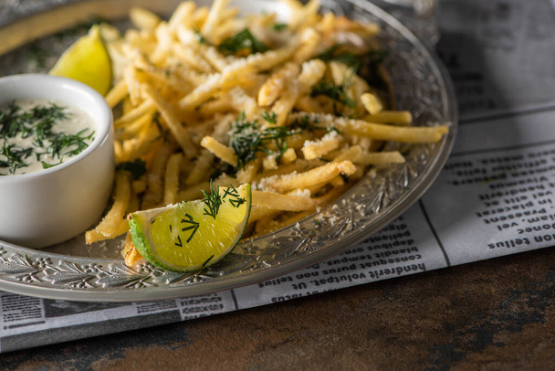 selective focus of sliced lime near french fries on plate  - Photo, Image