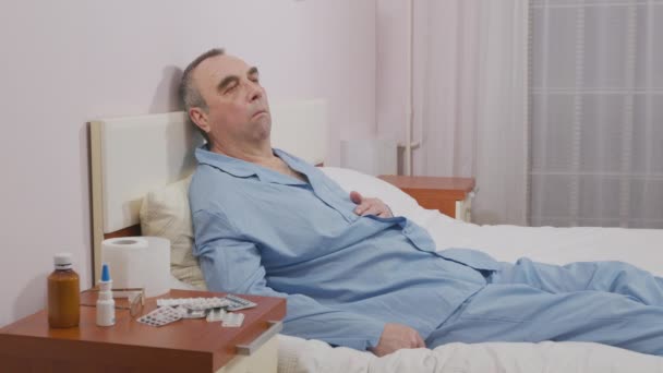 Kranker alter Mann hustet im Bett. - Filmmaterial, Video
