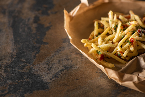 tasty french fries with ketchup on baking paper and marble surface  - 写真・画像