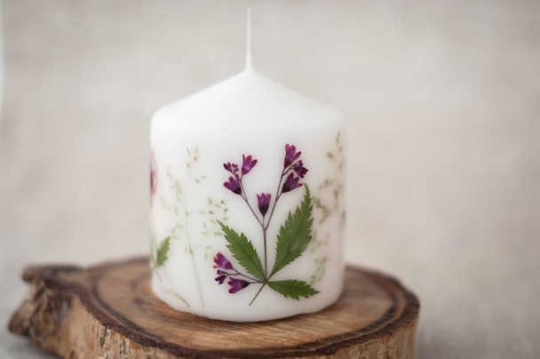 Candle with herbarium flowers. dried red flowers. on linen background - Photo, Image