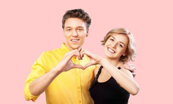 happy couple in love making heart shape on  background - Фото, зображення