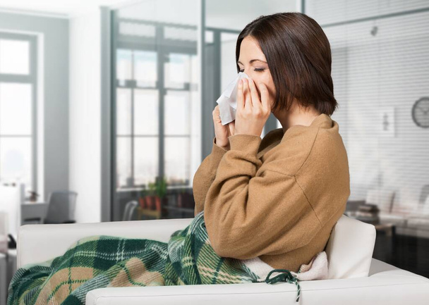 Nuori nainen flunssa olohuoneessa
 - Valokuva, kuva