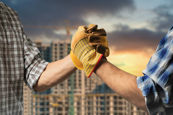construction clenching with hands on building background - 写真・画像