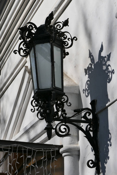 Lanterna de ferro fundido montada na parede em design de ornamento com aberturas
. - Foto, Imagem