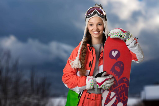 молода жінка в лижному костюмі зі сноубордом
 - Фото, зображення