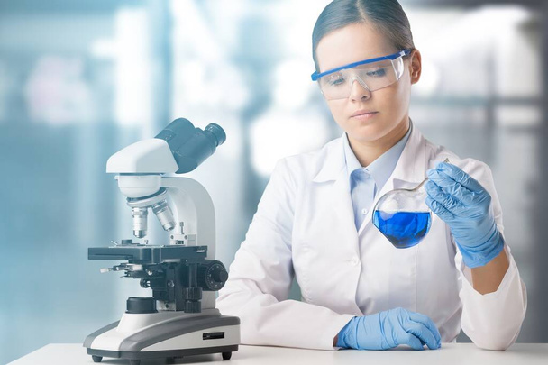Молодая женщина использует микроскоп в лаборатории
   - Фото, изображение