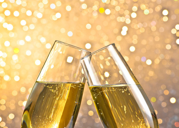 detail of a champagne flutes with golden bubbles on light bokeh background - Foto, Imagen