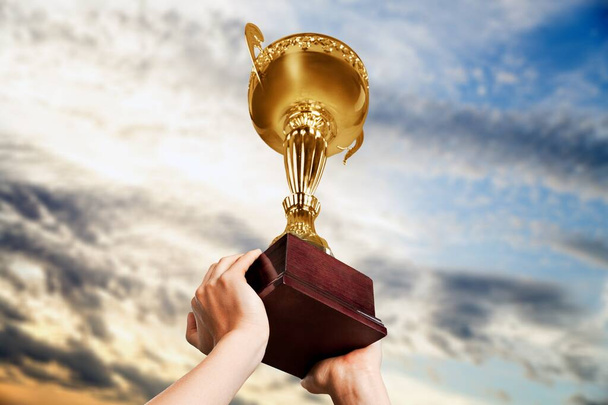 golden trophy cup in hands  - Photo, Image