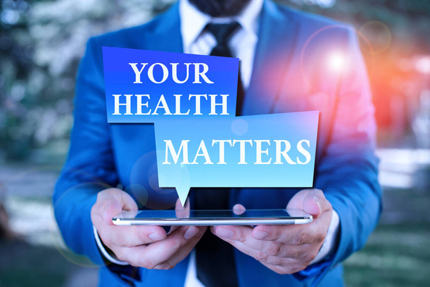 Szövegírási szöveg az egészségügyről. Üzleti koncepció a jó egészség legfontosabb többek között üzletember kék lakosztály nyakkendővel tartja lap tetején a kezét. - Fotó, kép