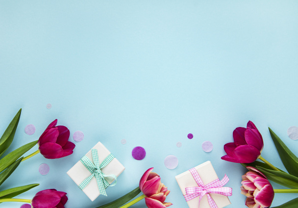 Primavera tulipa flores e caixa de presente no fundo azul pastel de cima em estilo flat lay. Saudação para o Dia das Mulheres ou das Mães
. - Foto, Imagem