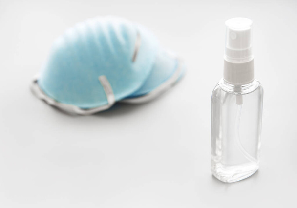 Respirator masks and antiseptic spray on white background - Фото, изображение