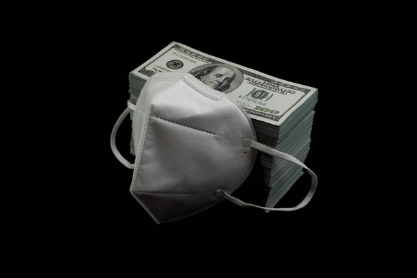 Lekarz maska ochrony wirusów i pieniędzy stos 100 Nas dolarów banknot dużo na czarnym tle, To było to kosztowne ceny i wysokiej cenie koncepcji produktów - Zdjęcie, obraz