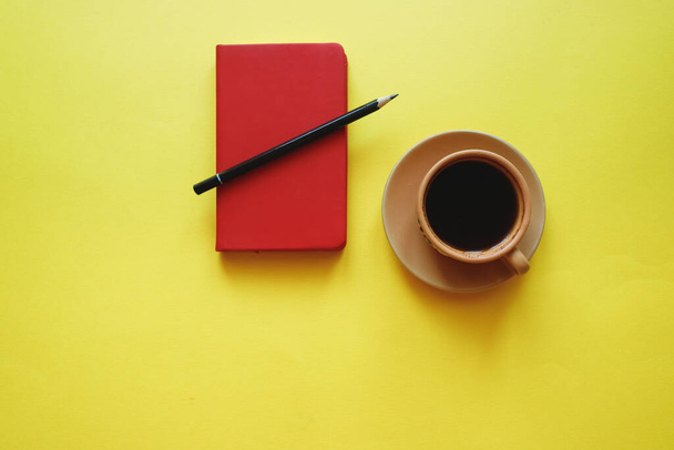 xícara de café no fundo amarelo com bloco de notas
 - Foto, Imagem