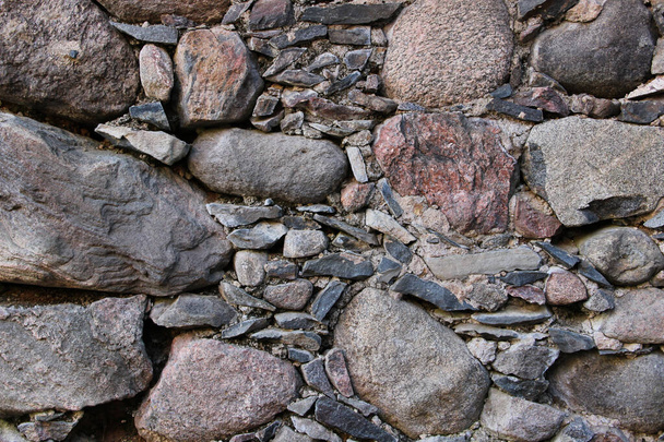 Alte Mauer aus Felsen. Mittelalterliche Oberfläche aus Ziegeln. Textur eines alten Felsens, der mit einem Zement verklebt ist. - Foto, Bild