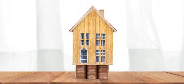 家の模型と硬貨。住宅と不動産の概念。ホームビジネスのアイデア - 写真・画像