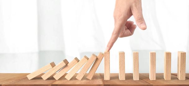Hand stopping the Domino effect stopped by unique, Business Ideas - Photo, Image