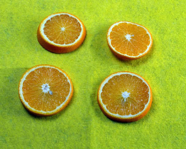 čtyři plátky pomeranče leží na stole - Fotografie, Obrázek