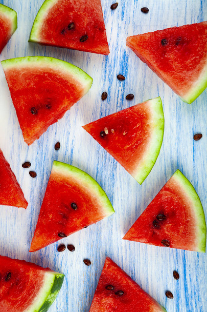 Pieces of watermelon on a blue wooden table, top view. Delicious dessert. - Fotografie, Obrázek