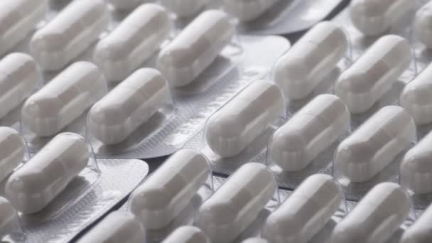 Close-up shot van verschillende pillen vallen op tafel met tabletten, farmaceutische industrie concept - Video