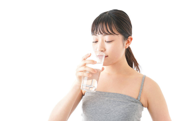 portrait of asian young woman drinking water isolated on white background - Foto, afbeelding