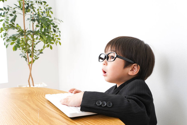 маленький мальчик учится с помощью настольного компьютера  - Фото, изображение