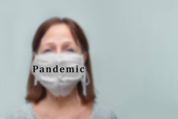 Mujer mayor con una máscara miedo problema contaminación del aire sobre un fondo blanco, concepto de cuarentena
. - Foto, Imagen