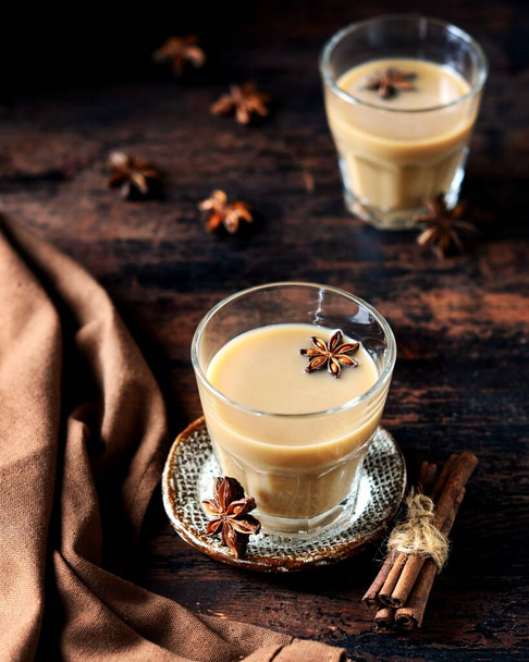 Herbata masala w szklanych szklankach na ciemnym drewnianym tle. rustykalny - Zdjęcie, obraz