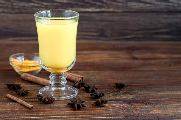 Masala çayı ya da kışın bağışıklığı arttırmak için kullanışlı süt ve baharatlı geleneksel Hint içeceği. Ahşap bir arka planda. Boşluğu kopyala - Fotoğraf, Görsel