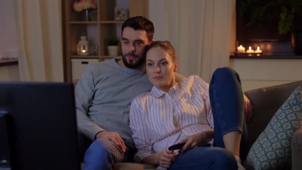 happy couple watching tv at home at night - Imágenes, Vídeo