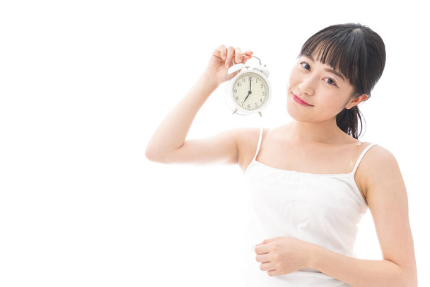 mladá asijská žena s budíkem hodiny izolované na bílém pozadí - Fotografie, Obrázek