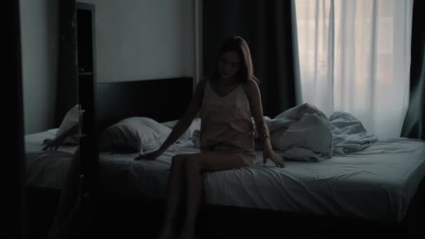 Young beautiful girl waking up in the morning and looks at the phone - Footage, Video