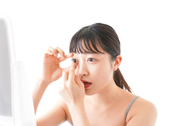 muotokuva aasialainen nuori nainen käyttäen silmä linssit eristetty valkoisella pohjalla
 - Valokuva, kuva